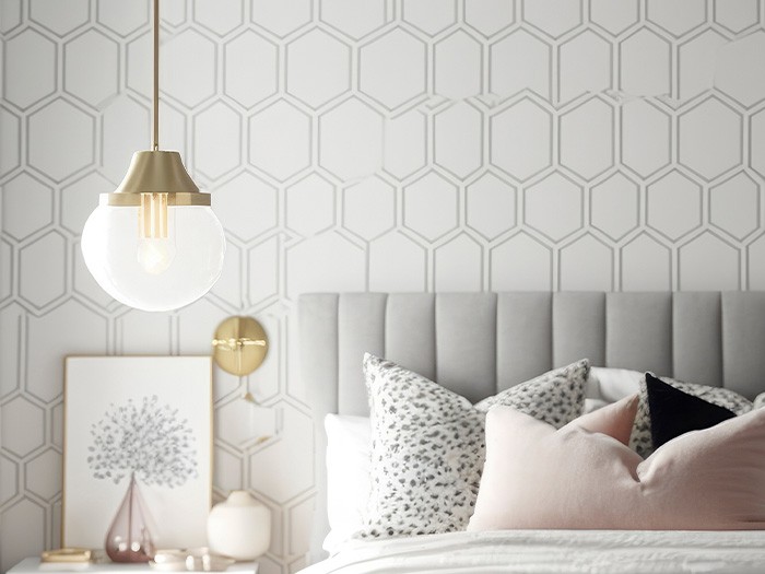 Chambre à coucher moderne, aux couleurs neutres, avec un papier peint en nid d’abeilles.