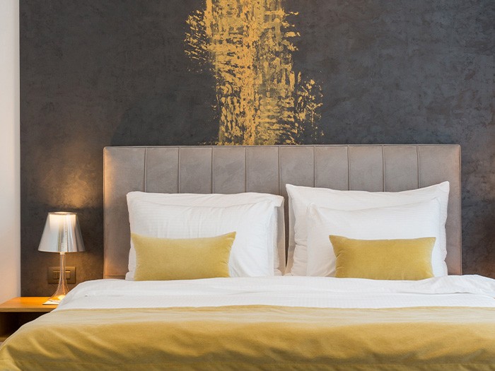 Chambre à coucher de style moderne avec des tableaux suspendus au-dessus du cadre du lit.